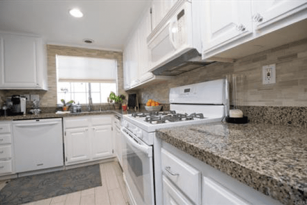 A Brown and Black Pattern Kitchen Counter With White Cabinets