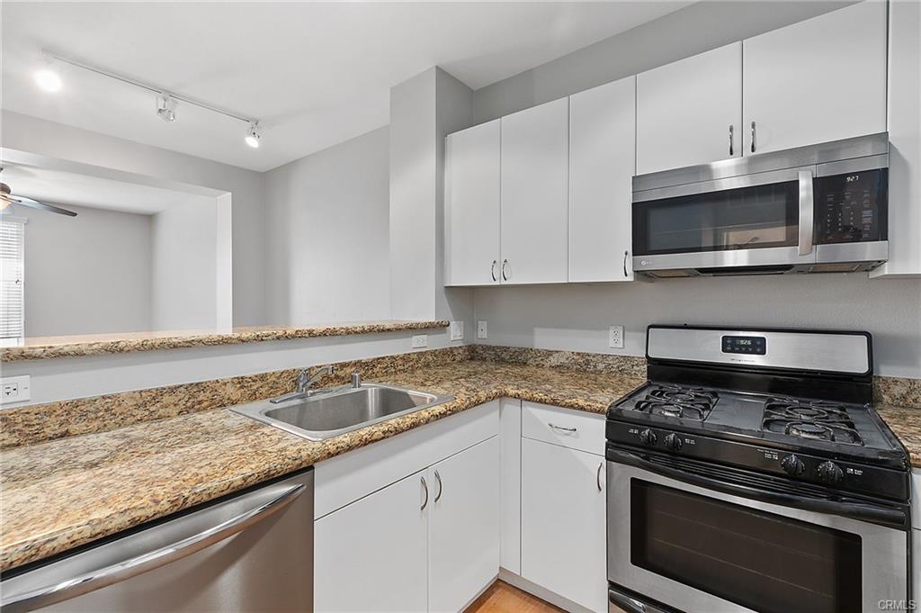 An L Shaped Kitchen Space With an Oven and a Stove