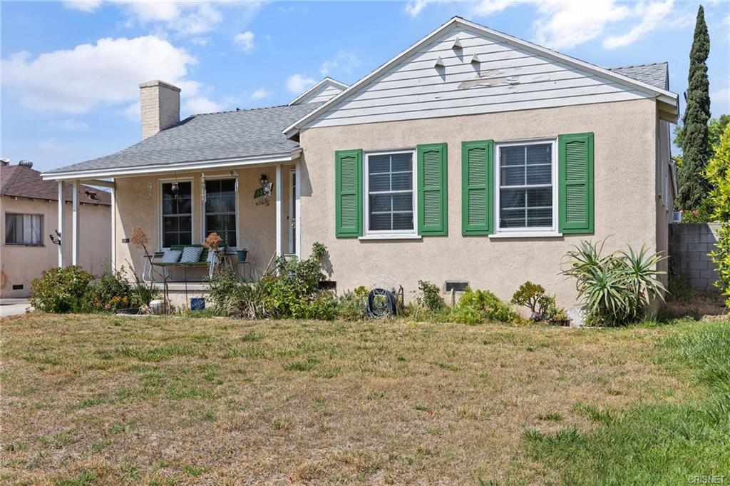 A House With a Front Lawn and Green Window Shutters